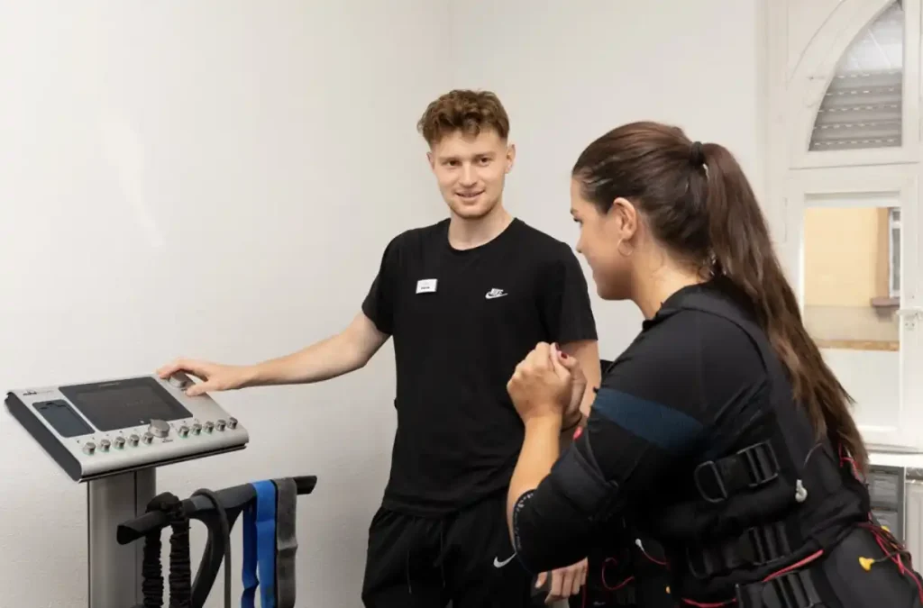 9 Vollbild: Trainer begleitet Mitglied beim EMS-Training